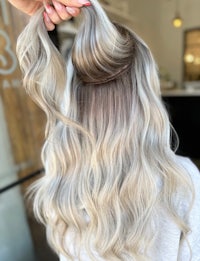 a blonde woman with long wavy hair in a salon