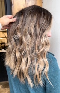 a woman with blonde wavy hair in a salon